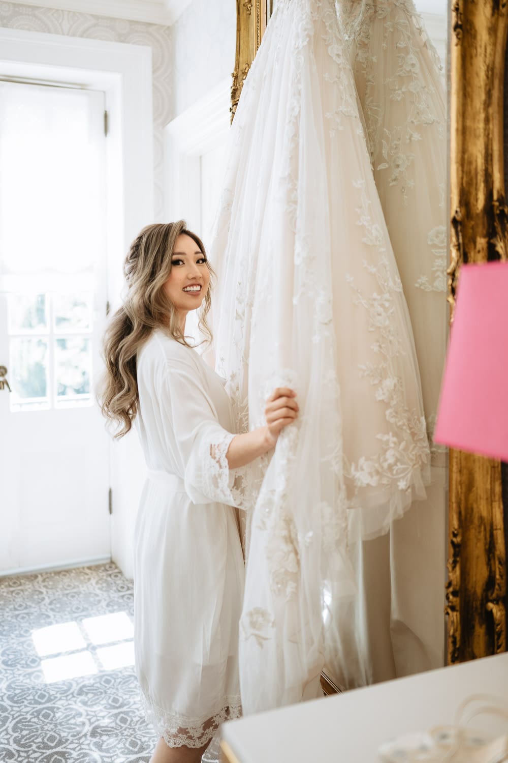 Bride with her wedding gown at the Graydon Hall bridal suite in front of mirror