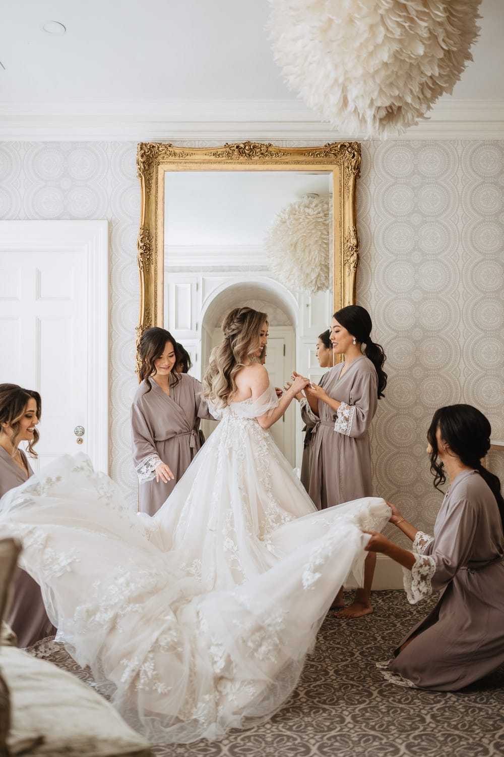 Bride and bridesmaids getting ready at the Graydon Hall bridal suite in front of mirror