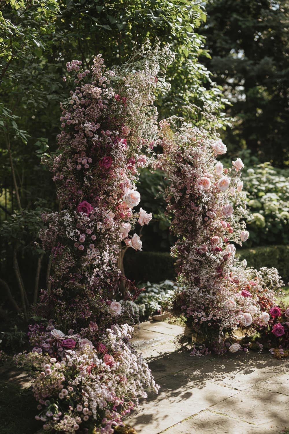 fuchsia themed flower arch at an outdoor garden wedding at the Graydon Hall in Toronto