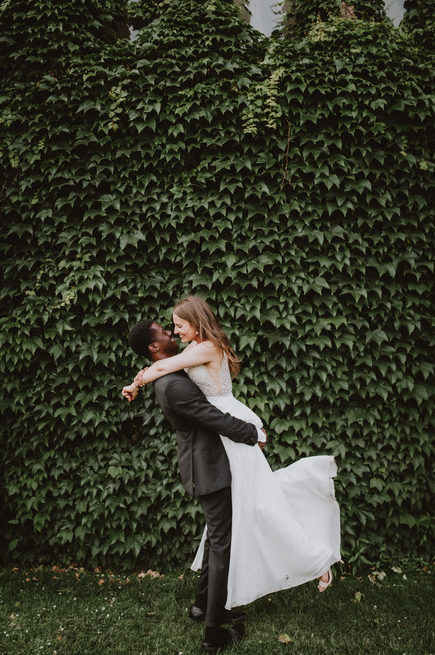 Adorable couple wedding photography at University of Toronto by a wall greeneries