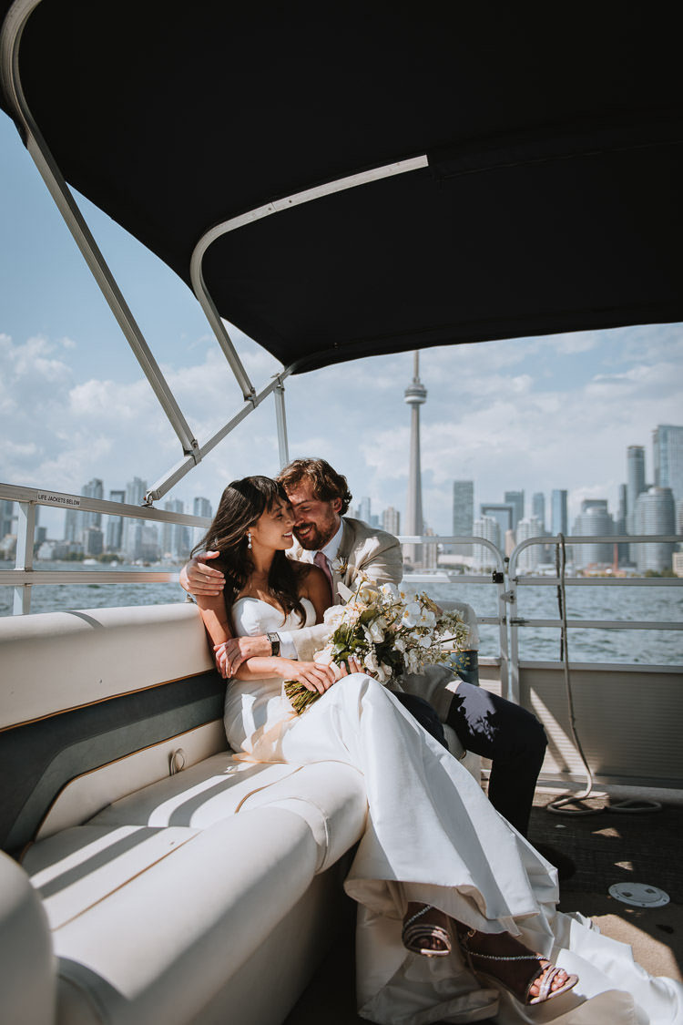 Fun bride and groom wedding photo on the water taxi with the Toronto Skyline backdrop