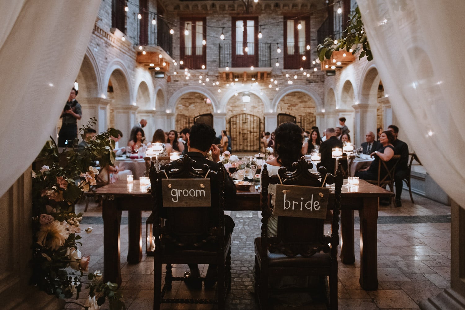 Head table setup from behind at the wedding reception in the Courtyard of Hacienda Sarria
