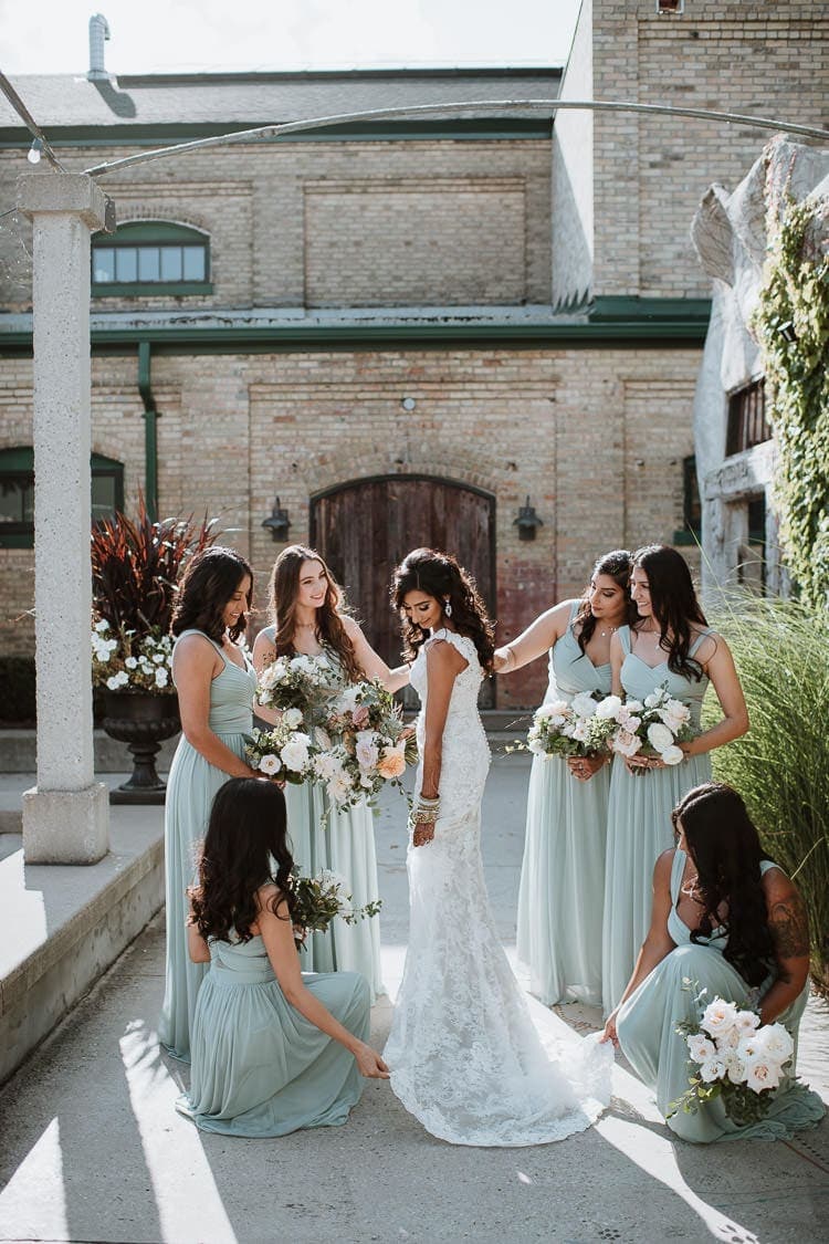 Bridesmaids giving bride the final touch up at the Patio of Hacienda Sarria in Kitchener, Ontario