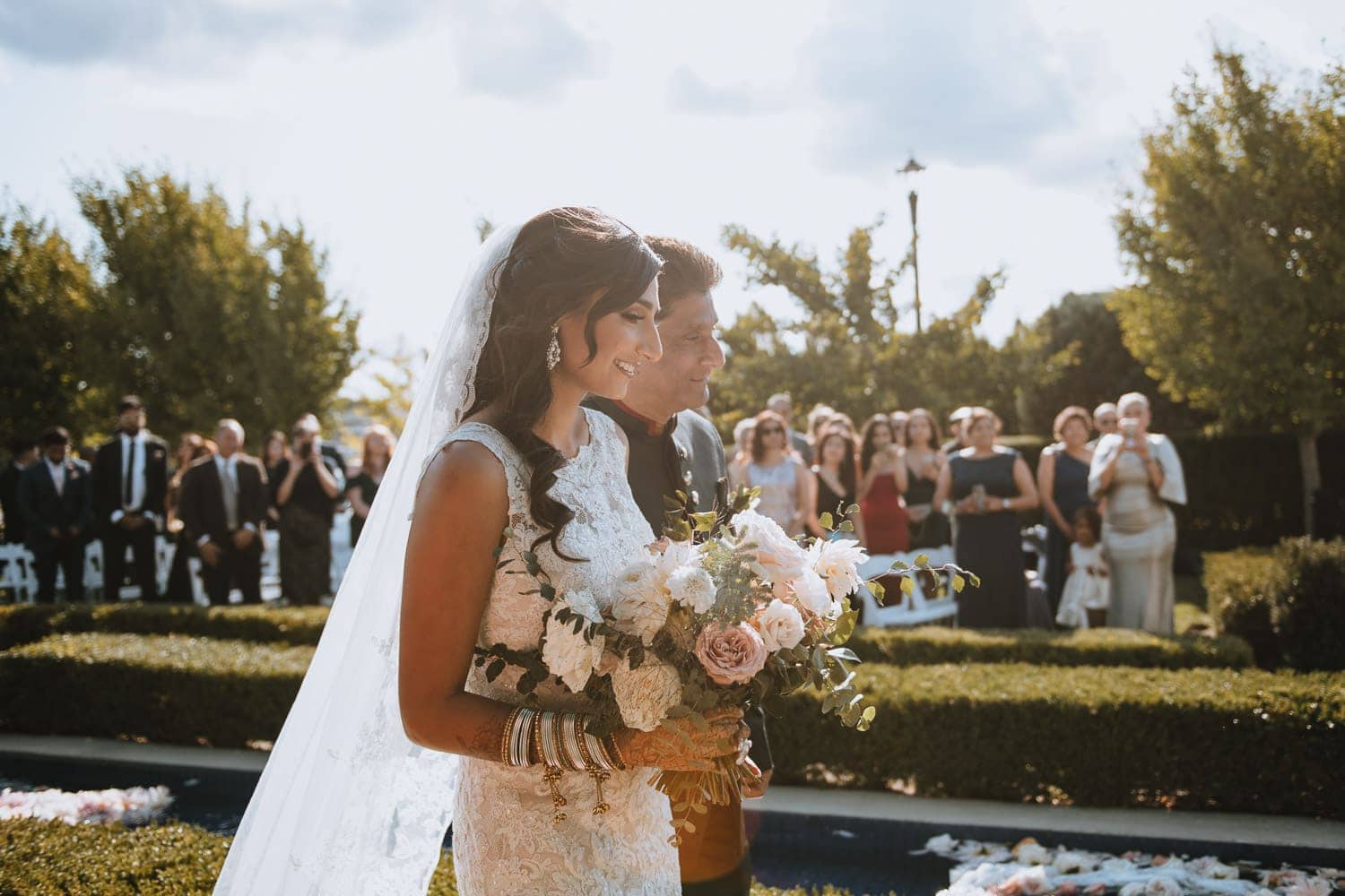 Bride and father walking down the aisle at the wedding ceremony in Hacienda Sarria