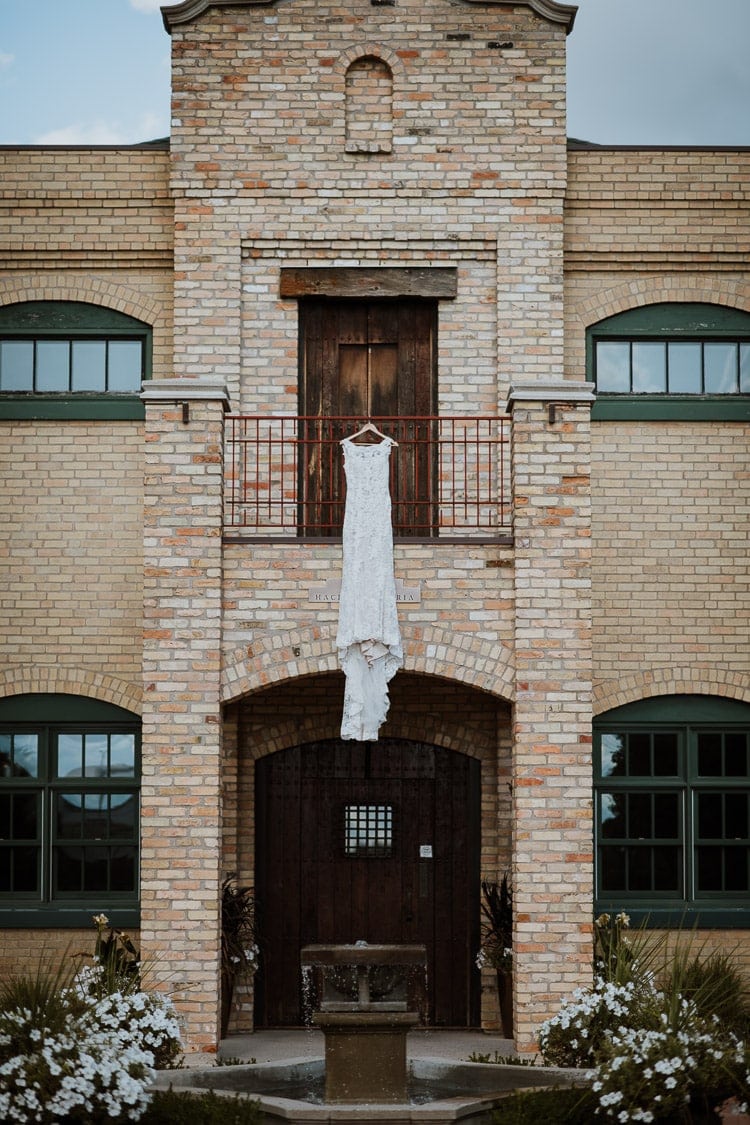 Wedding dress hanging outdoor in the garden of Hacienda Sarria