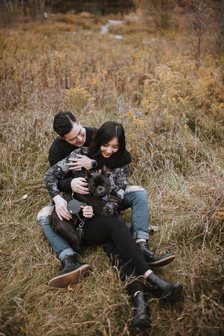 Carefree engagement session with their French bulldog pup sitting in a field in Don Valley Brickwork Park