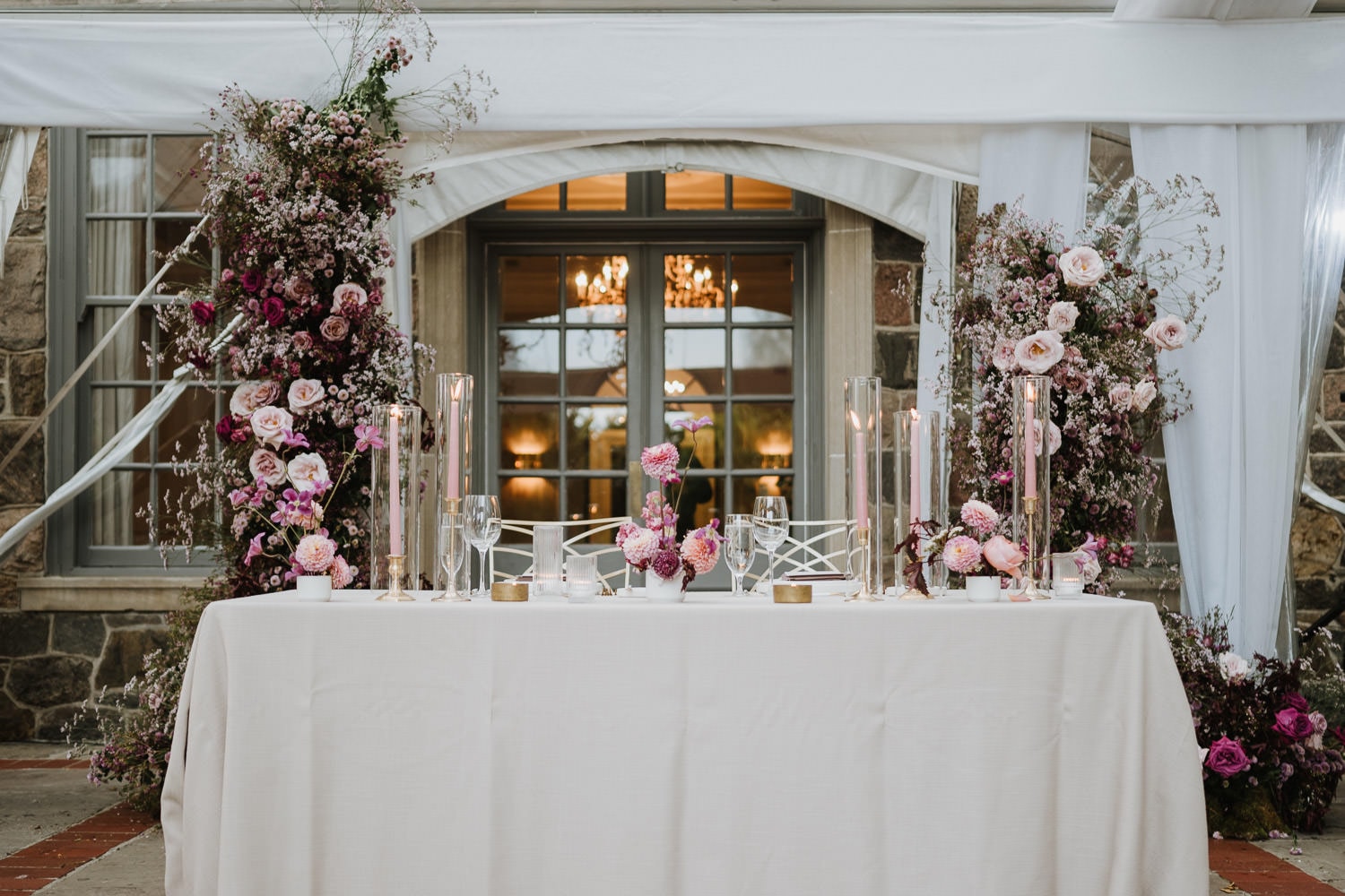 A head table setup with purple flower at the outdoor reception of Graydon Hall