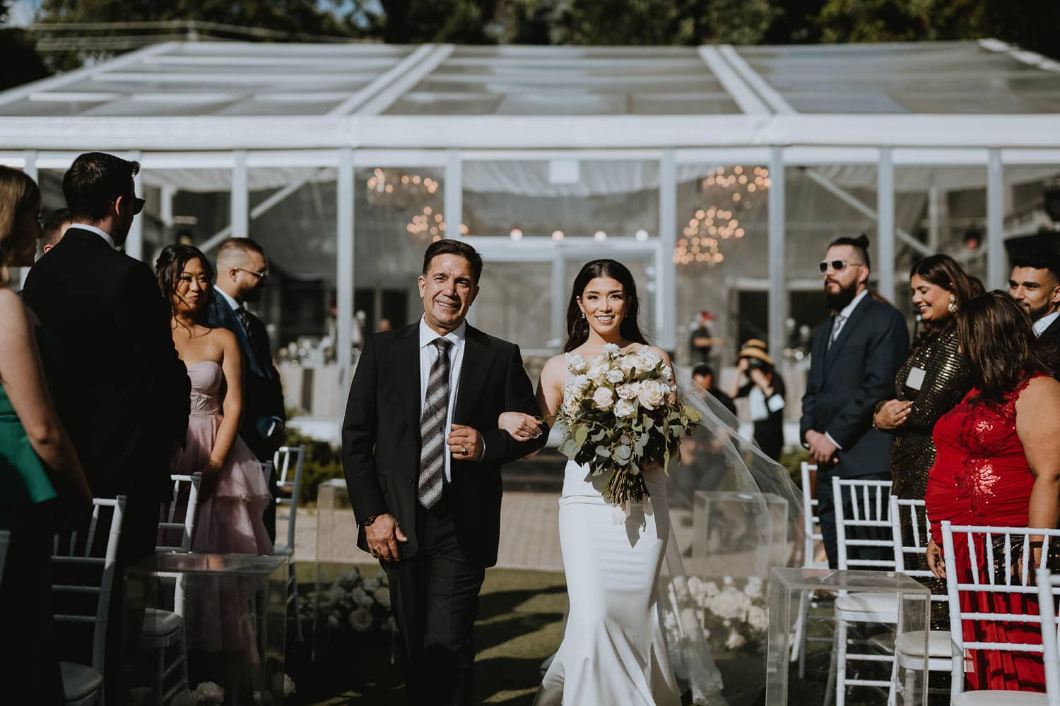 Bride walking down the aisle with her father at Casa Loma Garden